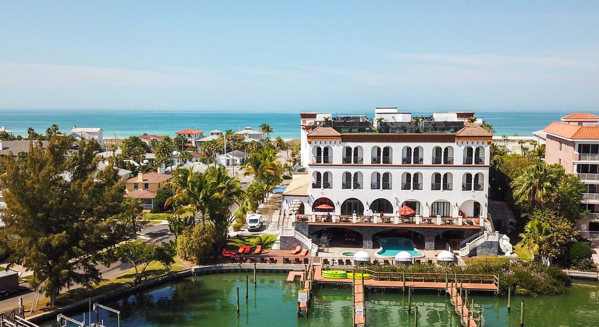 Exterior aerial of The Hotel Zamora showing tropical plants and the surrounding water