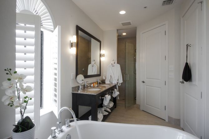 bathroom in hotel room with spa-style bathtub and hanging robe