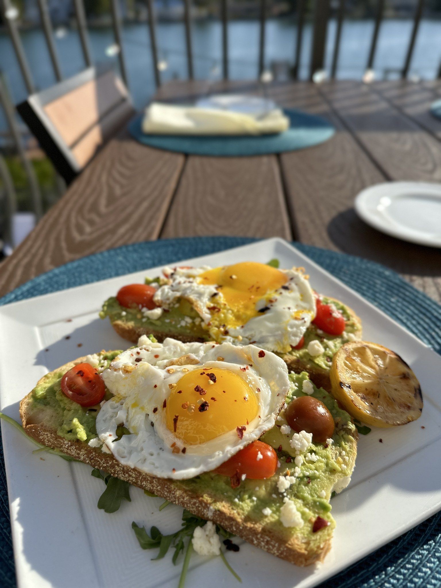 Plato de desayuno en mesa exterior del Restaurante Castilla de tostada de aguacate y huevos