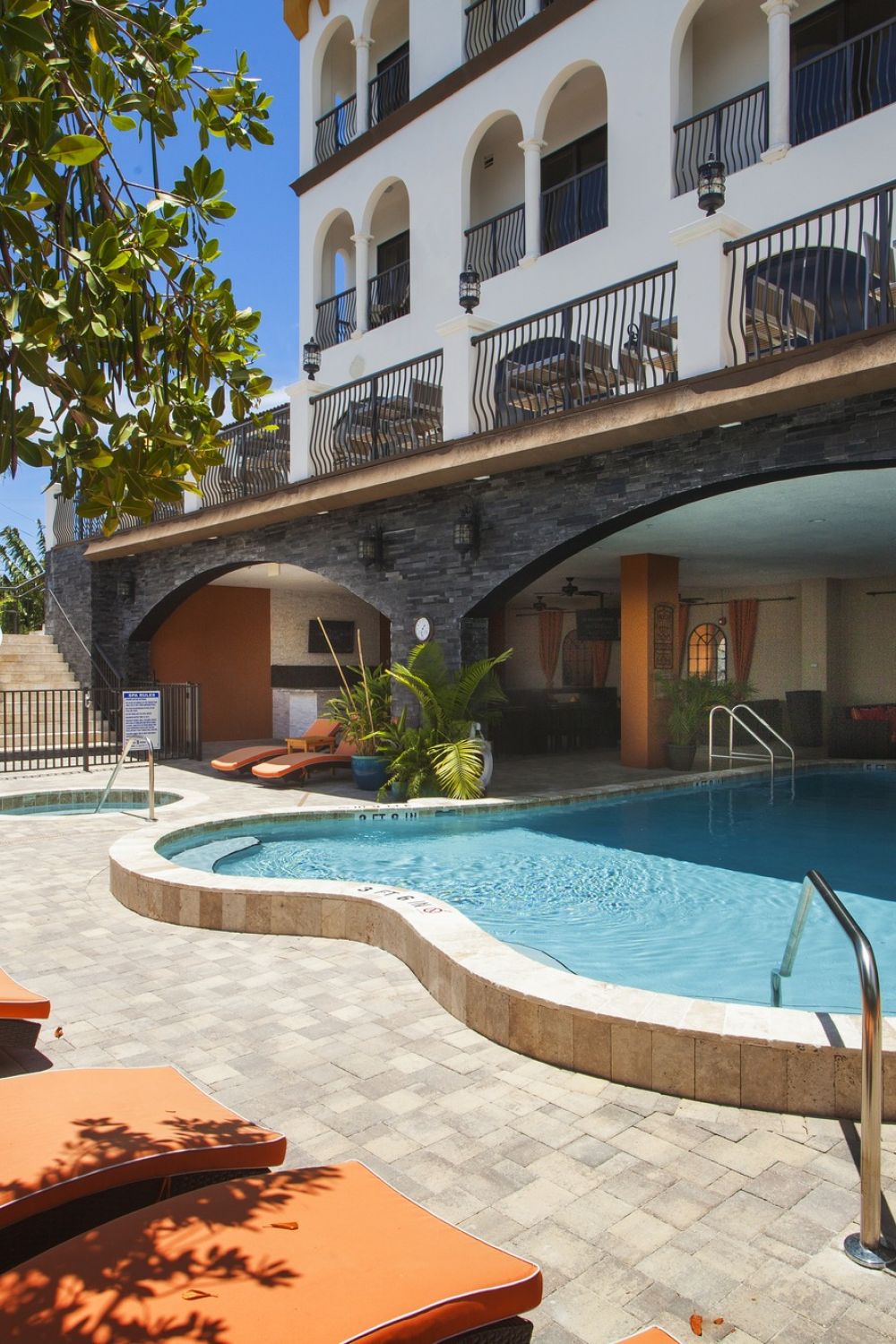 Exterior of The Hotel Zamora showing lounge chairs and entrance to the outdoor pool