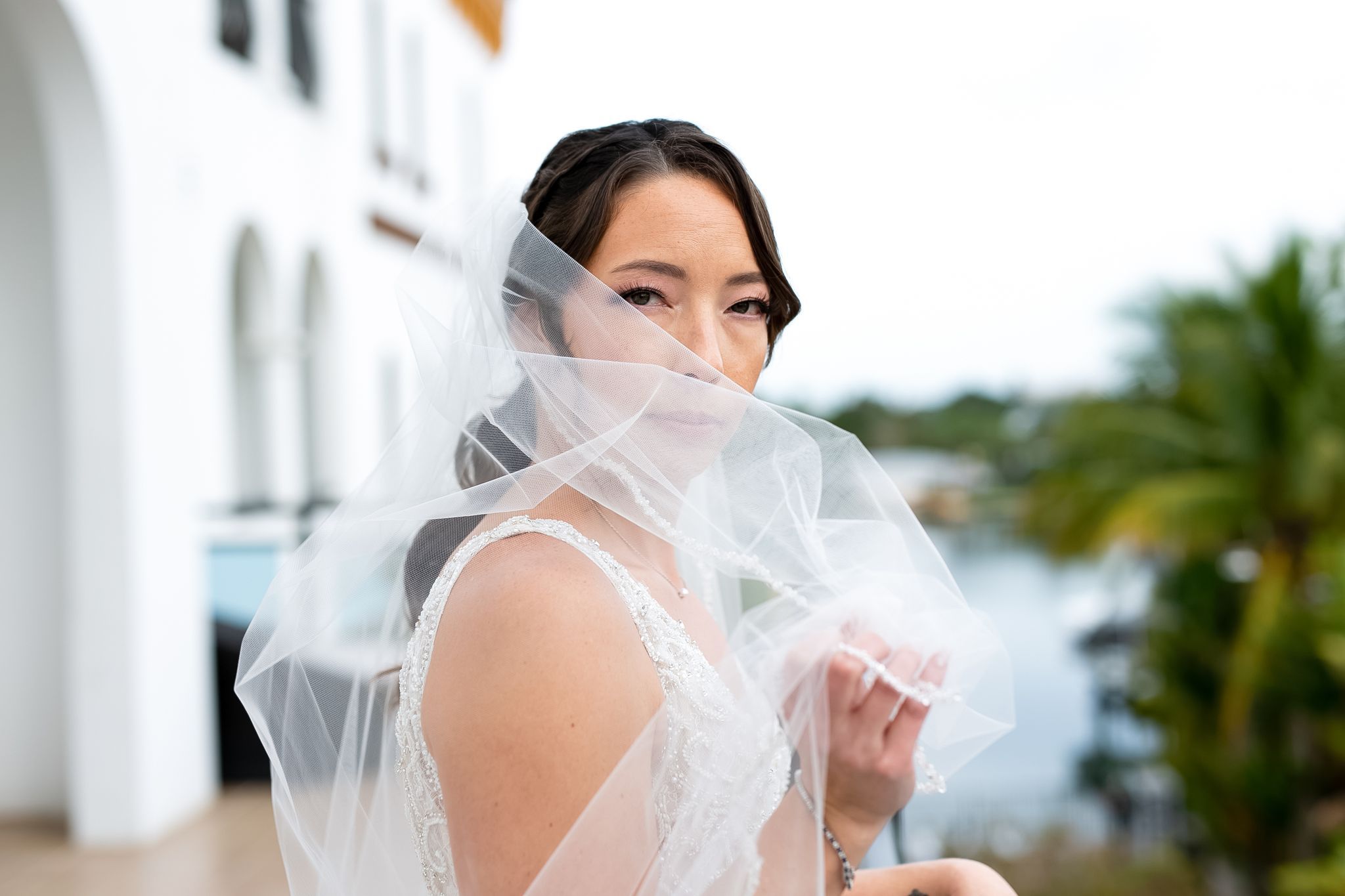 woman looking out from behind her wedding veil