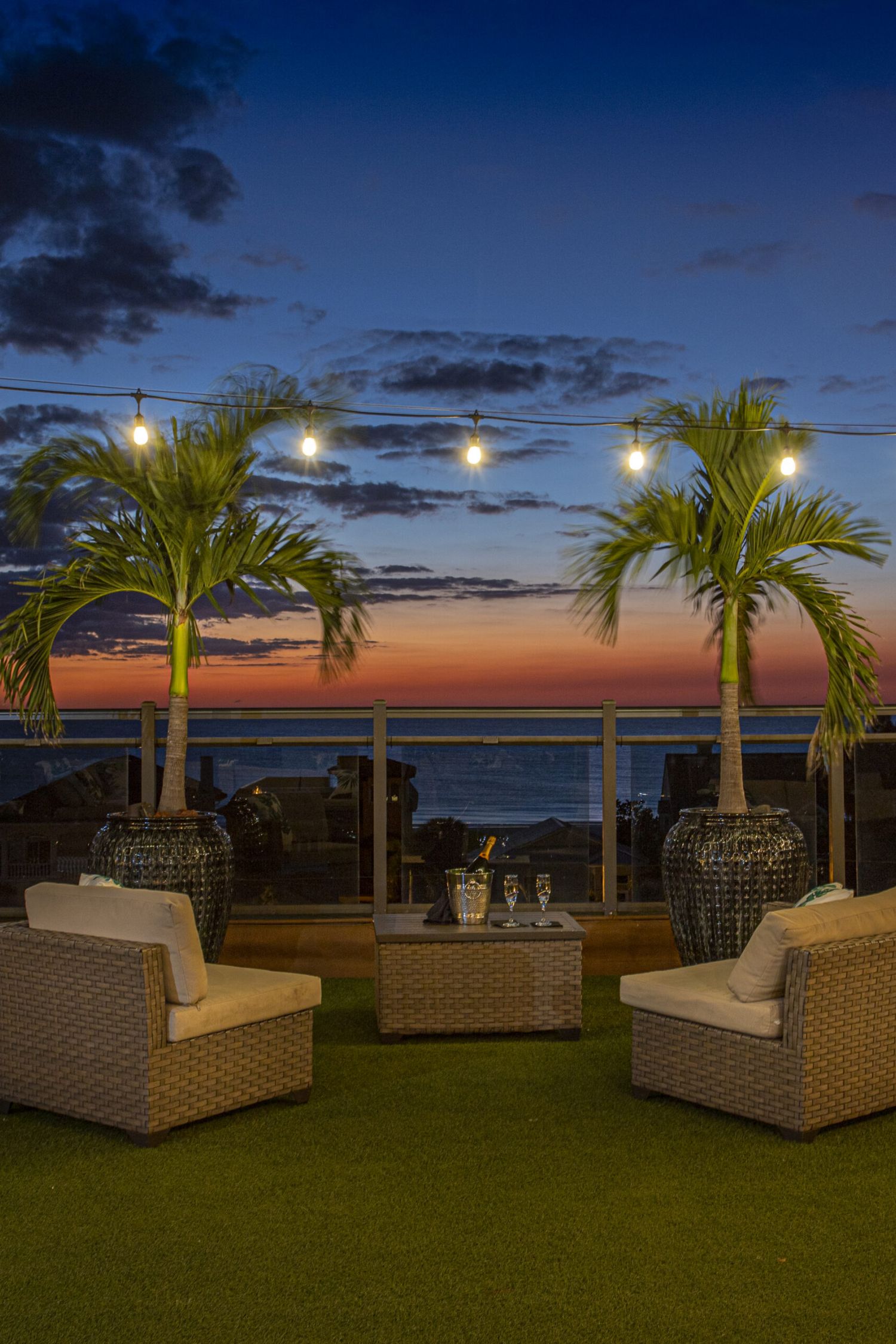 Rooftop bar at Castile Restaurant at sunset with tropical plants overlooking the water