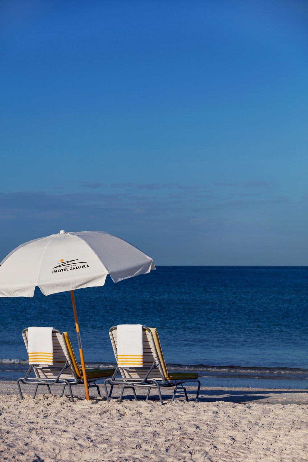 Two beach chairs and umbrella on the beach in St. Pete Beach, FL