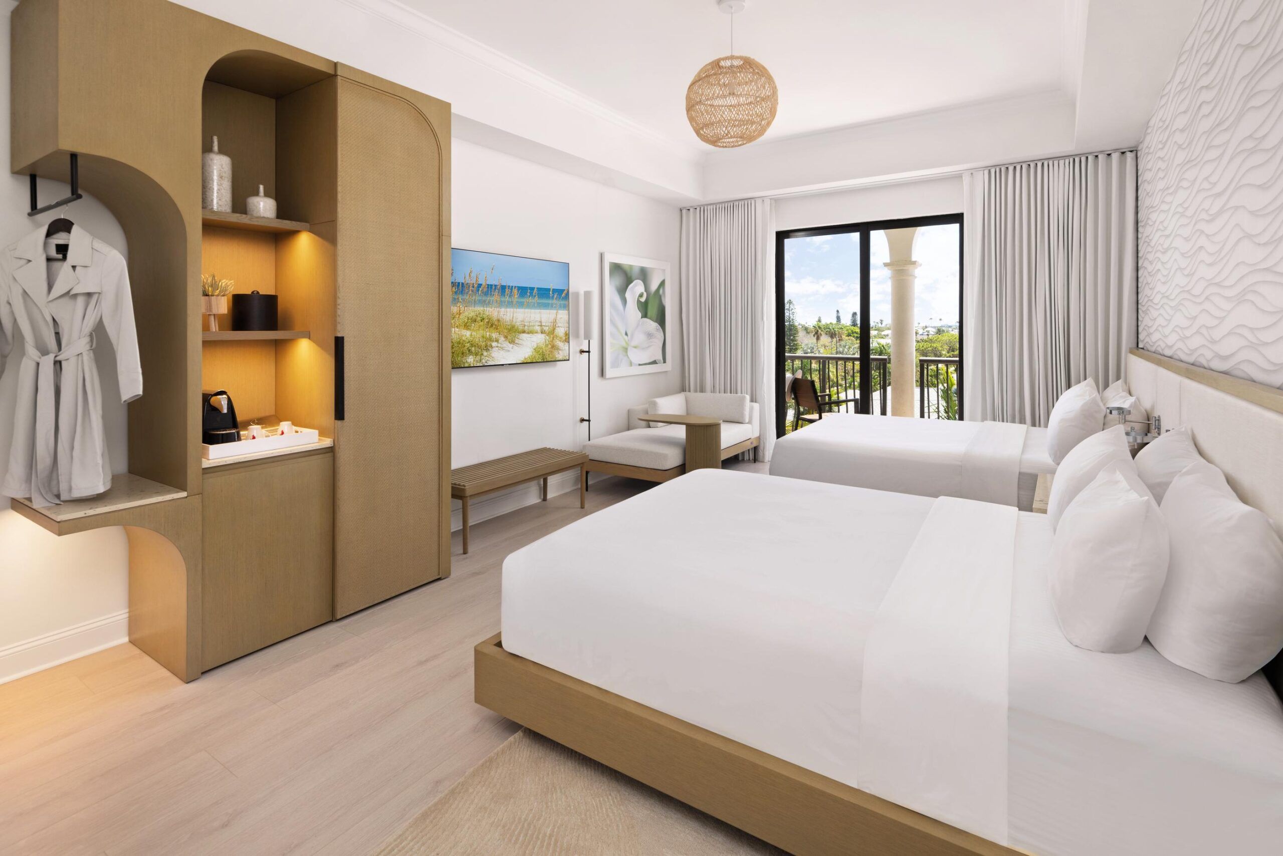 Modern Queen Room with two double beds, wooden furniture, a balcony with garden view, and coastal-themed decor.